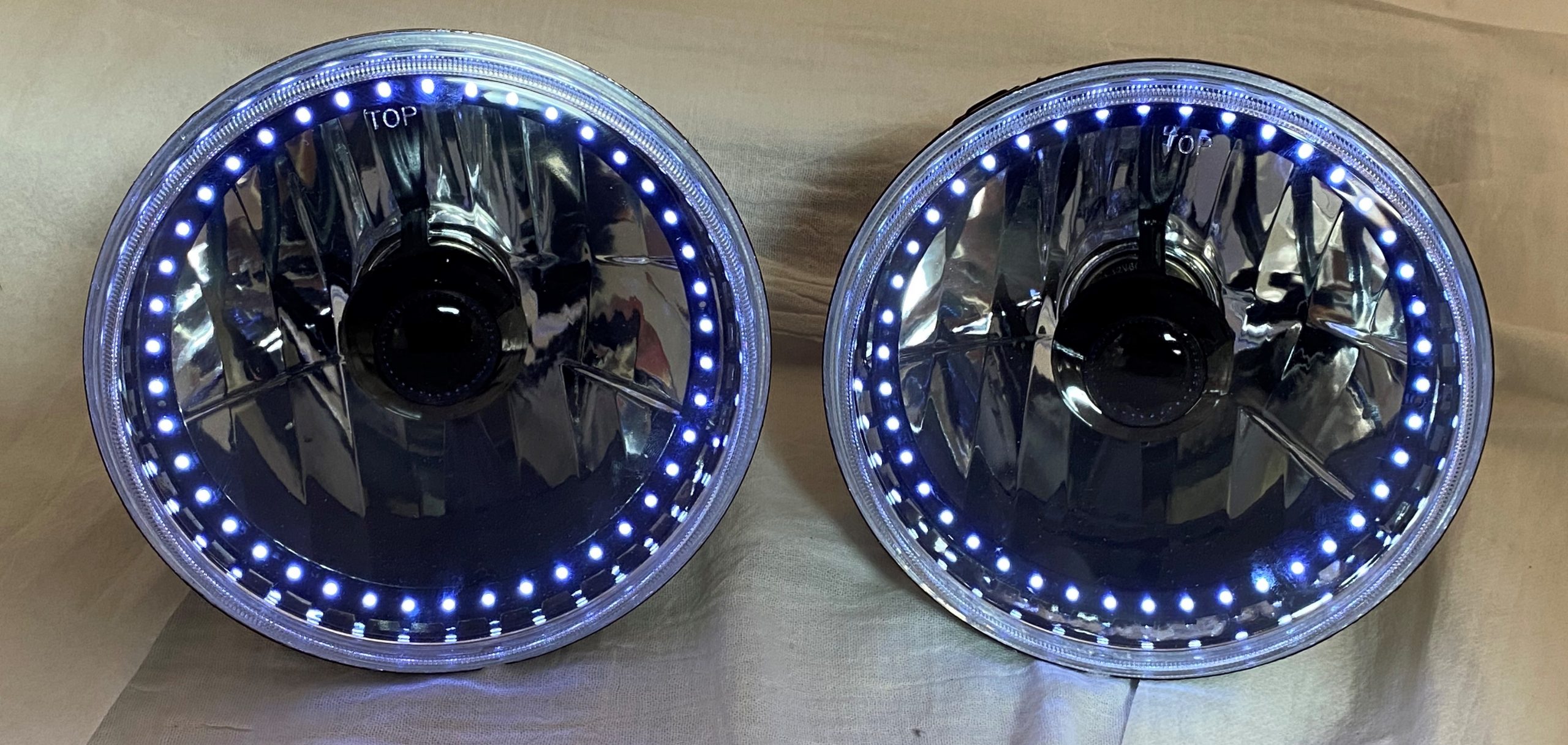 One Pair of 7 Inch Round Elite Diamond Single Color White Halo Black Illusion ™ Headlights with Clear Halogen Bulbs